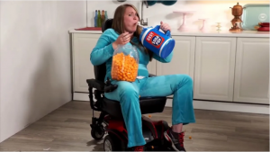 Woman in a wheelchair eating and drinking